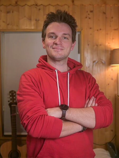 Adrien Coquelle homme bras croisé avec une veste rouge