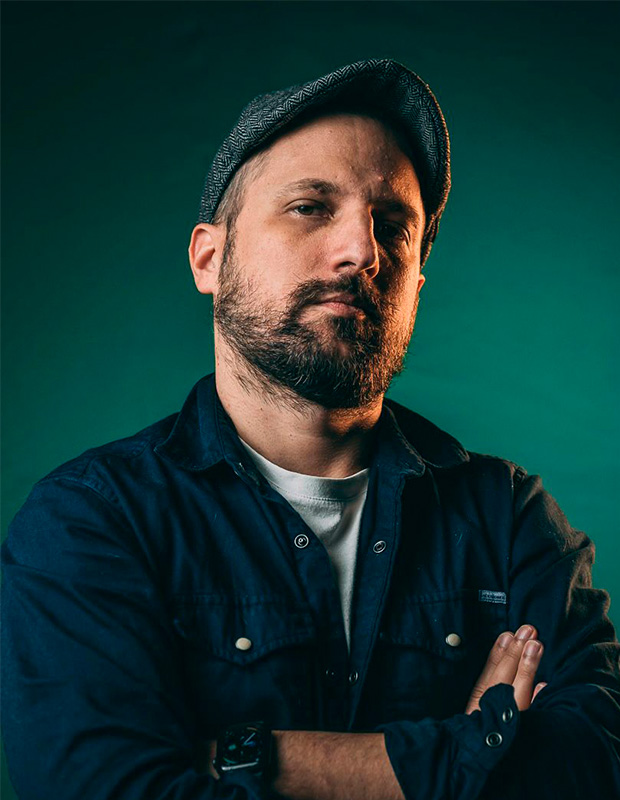 François Lamoureux homme debout bras croisée avec une barbe et une casquette