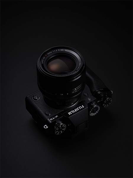 Appareil photo Fujifilm X-T5 sur fond noir avec objectif 56mm